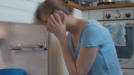 Close up beautiful woman calling plumbing master by smartphone. Plumbing in need of repair. Housekeeping