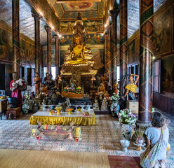 Naklejka premium Buddhist in prayer inside Wat Phnom, Phnom Penh, Cambodia