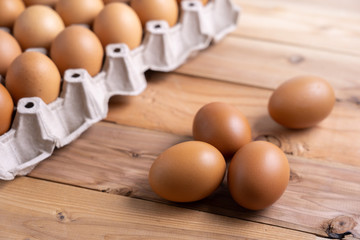 Brown Chicken Eggs on wooden background. and carton box