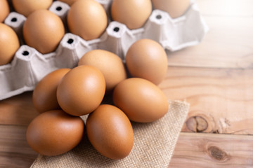 Brown Chicken Eggs on wooden background. and carton box