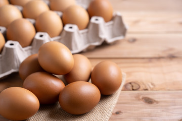 Brown Chicken Eggs on wooden background. and carton box