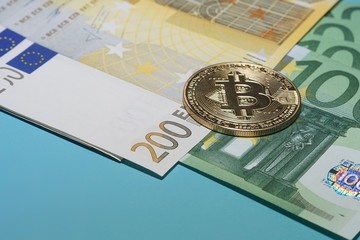Euro banknotes, with bitcoin coin, close-up on a blue background