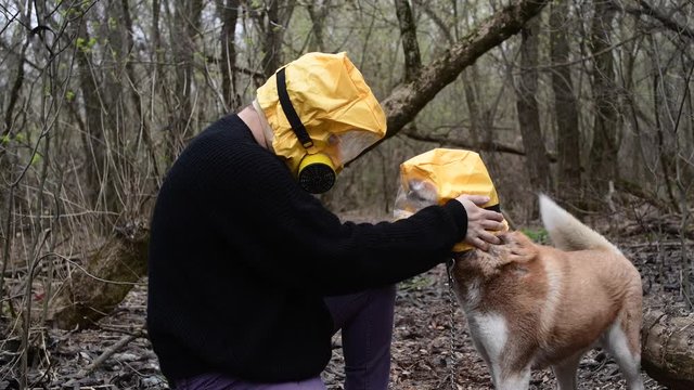 Man holding his dog, Huskey, in Yellow Radiation mask, coronavirus concept