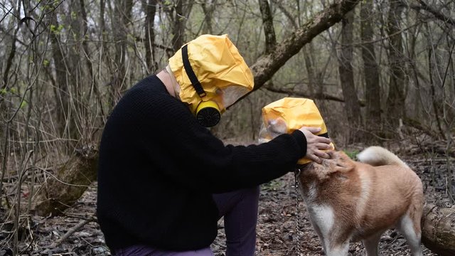 Зукыщт holding dog, in Yellow Radiation mask, coronavirus concept