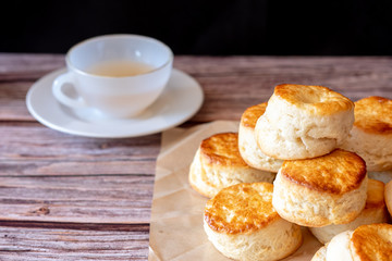 Close up group of fresh yummy tasty delicious Traditional British Scones and a cup of tea on wooden table black background.