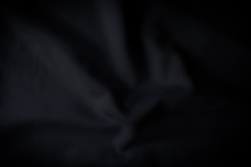Abstract folded black  clothes mesh background . Dark tone wallpaper