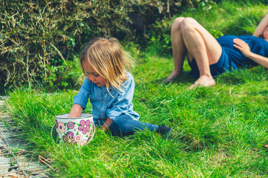 Preschooler with his mother in garden getting something from bucket