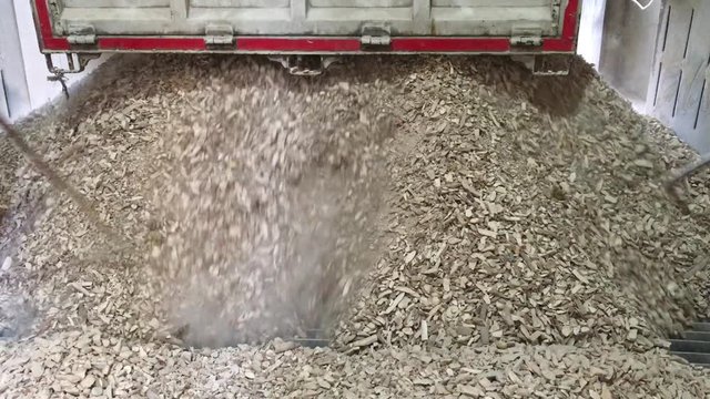 combine harvester working in a field tapioca and cassava pieces is pouring from truck to intake