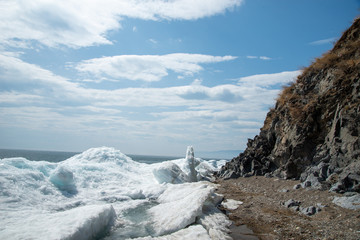 Natural background. Change of seasons.Baikal Lake in May morning.Spring landscape.The view from the rocks in the foreground of a snow-white fragments of ice floes. Northern nature
