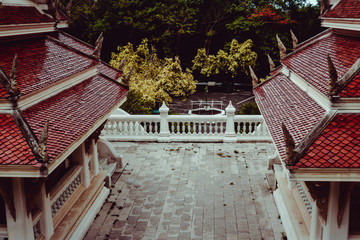 Buddhist temple in the tropical jungles near Pattaya Thayland. Old buildings covered in trees, red...