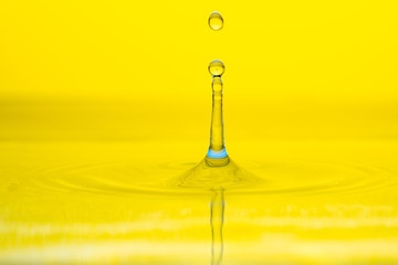 water drop splash on color gradient bright yellow surface macro