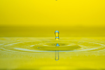 water drop splash on color gradient bright yellow surface macro