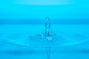 splash of blue water drop on a blue background close-up