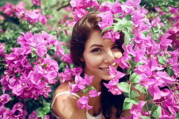 Close up portrait girl in the park on a background of pink flowers 