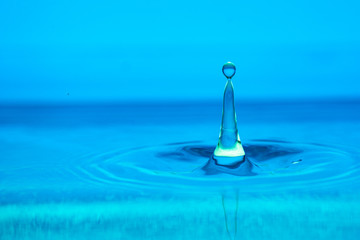 splash of blue water drop on a blue background close-up