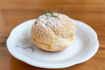 Choux cream placed on a white plate and wooden background