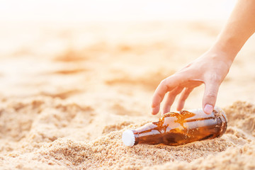 young man hand holding garbage collection. Discarding throw away junk water bottle on the sand, bring the sea to rot. beach environmental damage causing global warming. soft focus.
