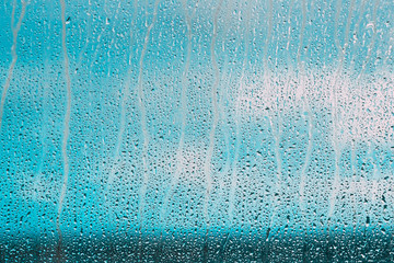 Drops Of Water Or Rain On Wet Glass Background. Moody Photo In Cold Blue Color