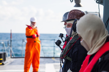 Seamen's on ship deck with safety equipments connect with vhf radio station.