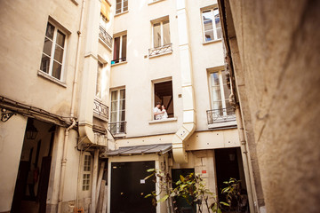 couple sitting on the bedroom window of an apartment in the French court. 