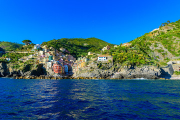Fototapeta premium Riomaggiore - Village of Cinque Terre National Park at Coast of Italy. Beautiful colors at sunset. Province of La Spezia, Liguria, in the north of Italy - Travel destination and attractions in Europe.