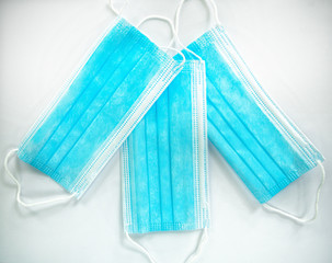 Three disposable blue medical masks are located on a white background.