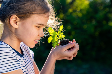 teen girl holding in hands green young plant. little farmer. gardening.