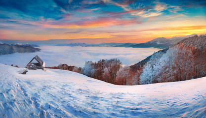 Fantastic winter sunrise in Carpathian mountains, Ukraine, Europe. Frosty morning view of the see of fog in mountain valley. Happy New Year celebration concept.
