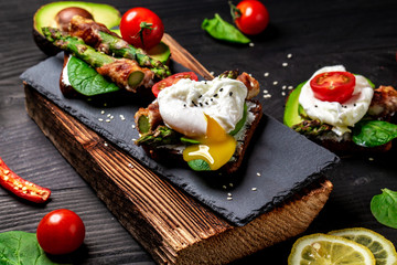 Toasts sandwich with asparagus in bacon and poached egg. Top view