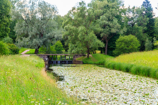 Black bridge-dam over the Slavyanka river in Pavlovsk park, Russia