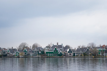 Obraz premium Marken village view through a wide canal. Traditionally cloudy weather.