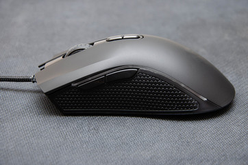 Black gaming mouse with side extra keys and a matte finish on a black background. mouse from...