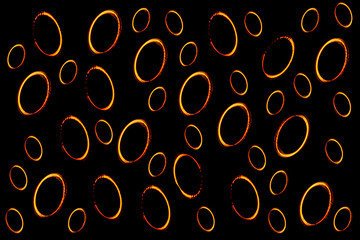 oval light circles in bright orange color on black background