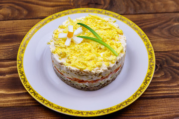 Traditional russian layered salad Mimosa with spring decoration Daffodil. Decoration is made of egg, green onion and carrot