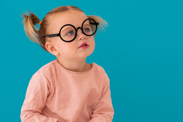 Portrait of beautiful cute model in trendy round sunglasses. Casual 1 y.o. girl posing isolated on...