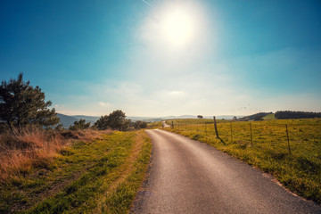 Fototapeta na wymiar Country road on the mountain on a spring sunny day. Rural landscape. Cantabria, Spain, Europe