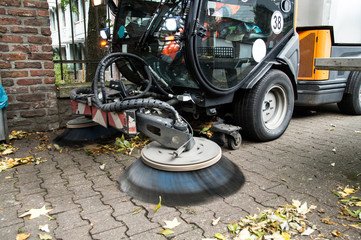 Street cleaning cleans the sidewalk with a sweeper