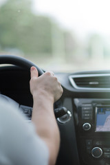 A woman's hand driving a car on a Sunny day