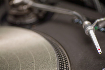 Close up of the arm of a modern turn table as part of a dj set 