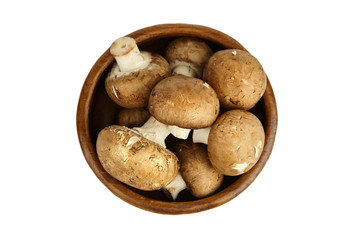 Mushrooms in wooden bowl isolated on white background, top view. Fresh brown champignons. Uncooked food ingredient