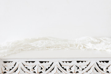 background Image of vintage table and lace fabric in front of white wall. ready for product display