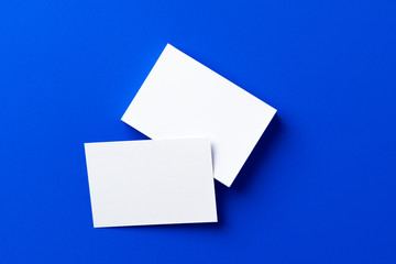 Blank white businesscards on classic blue background