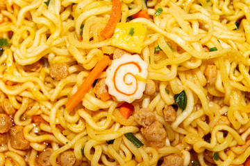 Cooked instant noodles with spices, dried vegetables and freeze-dried meat. Close up.