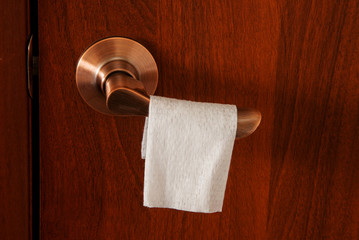 A disinfectant cloth is hanging on the doorknob.