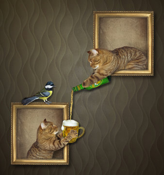 The beige cat is leaning out of the picture and pouring beer for his friend at an art gallery. A bird is sitting on a frame.