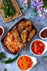 grilled chicken wings with rice and vegetables light background 