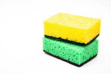 Sponge for washing dishes on a white background. Washcloth of green and yellow color. Two sponges are stacked on top of each other in macro. Yellow sponge on top