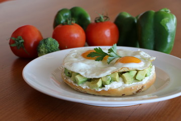 Fototapeta na wymiar Avocado on Bagel, Fresh avocado, cream cheese on bagel top with your choice of poached eggs or sunny side up eggs