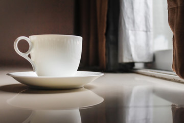 Smooth Focus and soft Focus,Hot coffee in a cup of coffee placed on the bedroom floor by the window in the morning was placed to prepare for drinking coffee before work.