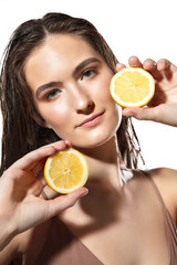 Energy. Close up of beautiful young woman with lemon slices on white background. Concept of cosmetics, makeup, natural and eco treatment, skin care. Shiny and healthy skin, fashion, healthcare.